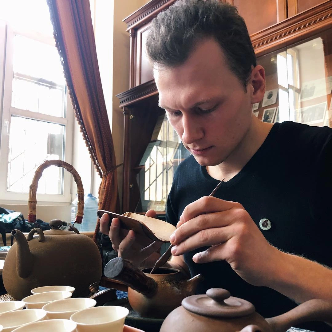 Владимир заваривает чай за столом на архивной встрече Russian Tea Lovers